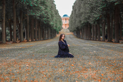 Full length of portrait woman sitting at park