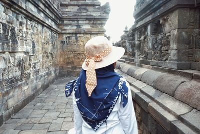 Rear view of woman standing amidst buildings