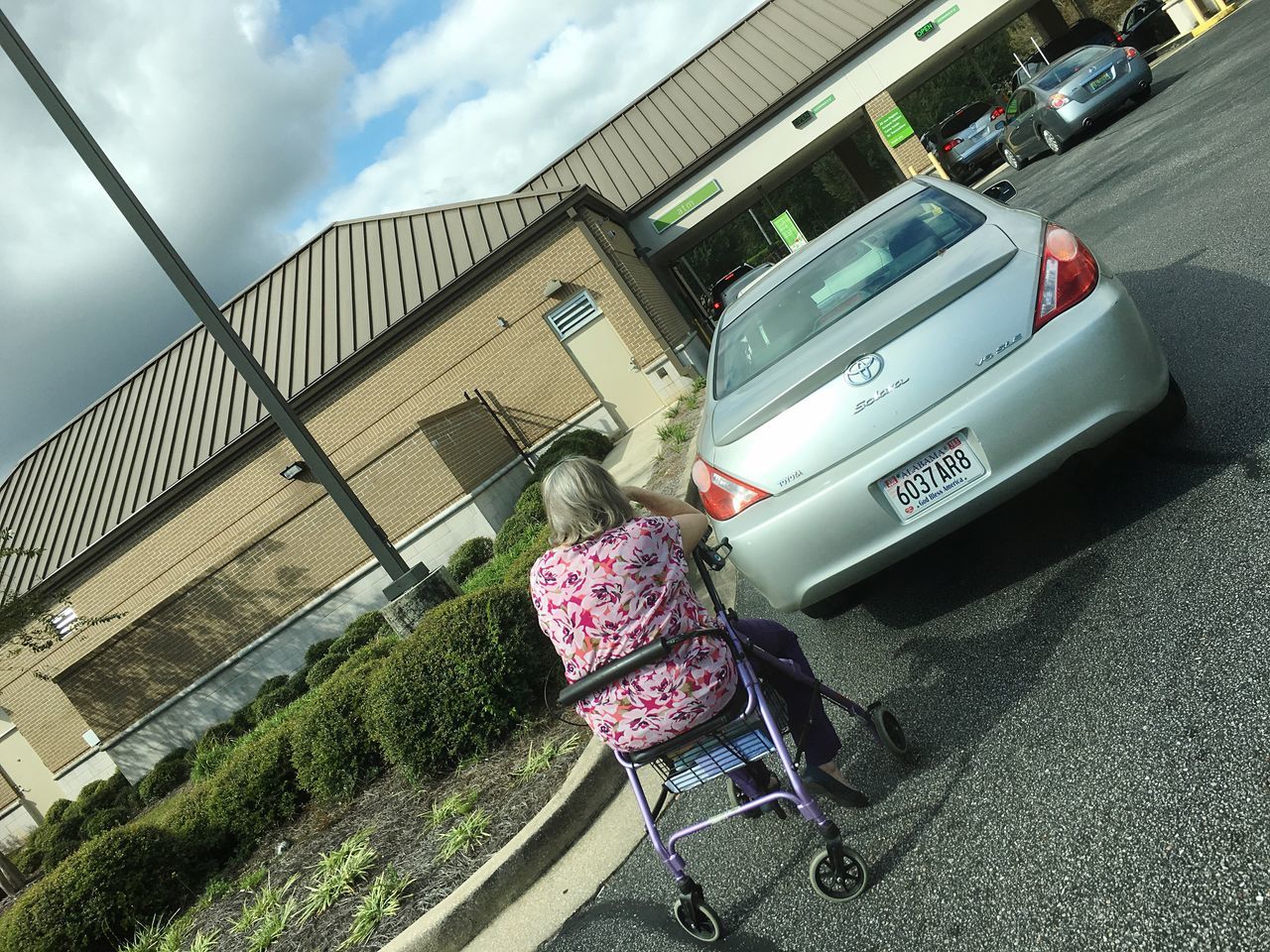 REAR VIEW OF WOMAN STANDING ON ROAD