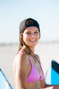 Portrait of young woman in bikini standing at beach