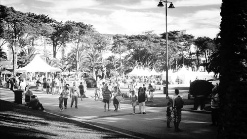 People on road against cloudy sky