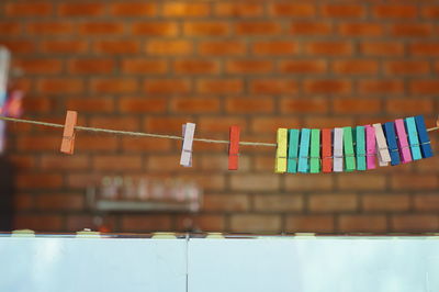 Close-up of clothespins hanging against wall