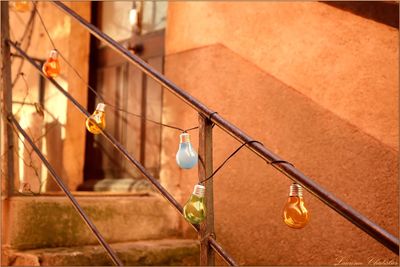 Close-up of electric bulb decoration on railing