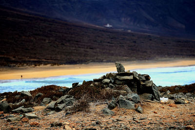 Scenic view of rocky mountain by sea against sky