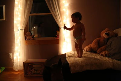 Baby standing on bed at home during night