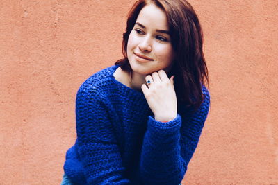 Smiling woman against orange wall