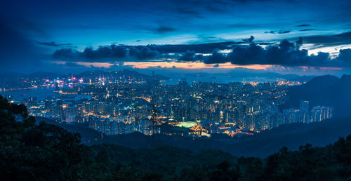 High angle view of illuminated cityscape against sky at night in hong kong