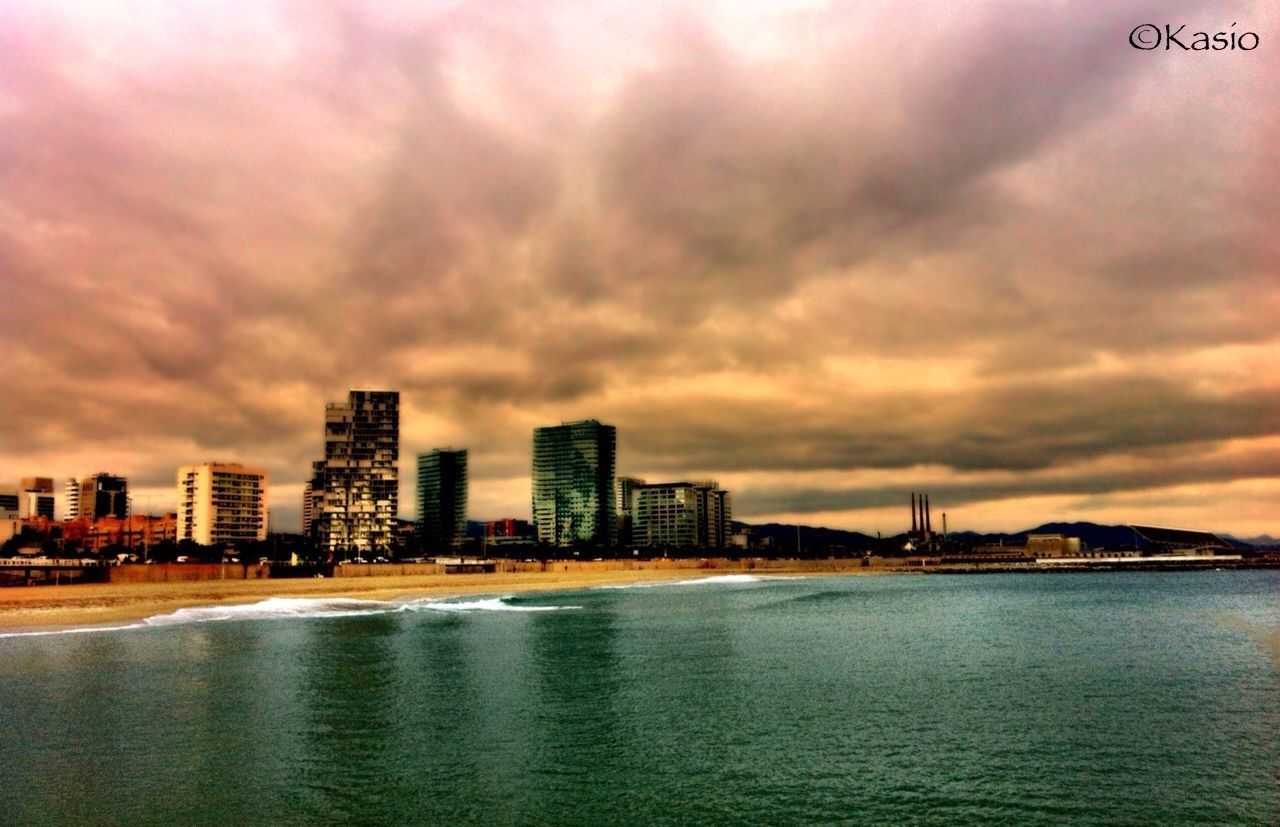 water, building exterior, sky, waterfront, architecture, city, built structure, cloud - sky, sea, cloudy, cityscape, river, cloud, dusk, skyscraper, urban skyline, sunset, illuminated, residential building, scenics