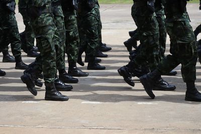 Low section of soldiers walking on road