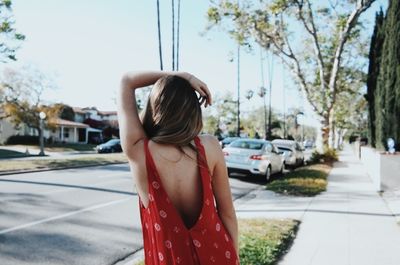 Woman standing by car in city