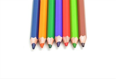 High angle view of multi colored pencils on white background