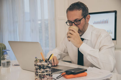 Business man with surgical masks working in the office during lockdown for coronavirus covid-19. 