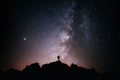 Silhouette man standing against star field at night