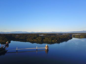 Scenic view of lake against clear blue sky