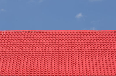 Low angle view of pink fence against blue sky