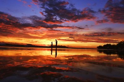 Scenic view of lake against orange sky