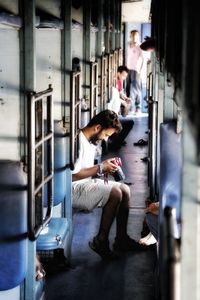 Woman sitting on train in corridor