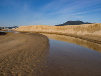 Water course on the beach with sand walls