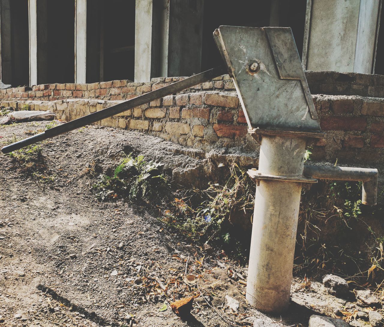 RUSTY METAL PIPE AGAINST BUILDING