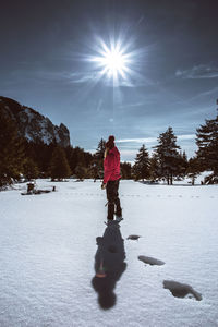 Full length of woman standing on snow covered field against sky