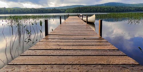 Wooden pier on lake against sky