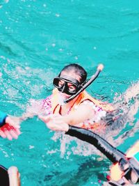 High angle portrait of woman snorkeling in sea