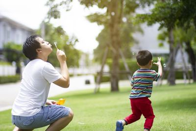 Rear view of father and son on tree