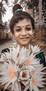 Portrait of smiling girl holding flowers