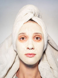 Closeup portrait woman facial mud mask hair wrapped in towel