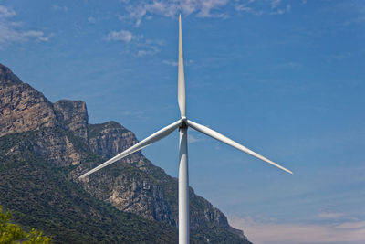 Low angle view of windmill against blue sky