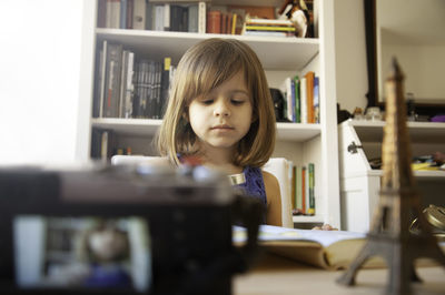 Portrait of girl in book at home