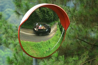 Reflection of people on side-view mirror