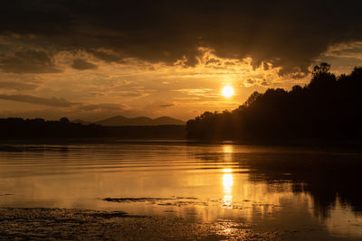 Scenic view of river against sky during sunset