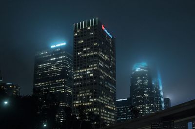 Low angle view of illuminated buildings against sky at night