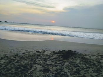 Scenic view of beach against sky during sunset