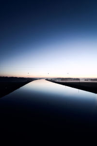 Scenic view of lake against clear blue sky