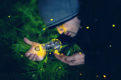Portrait of man holding illuminated glass