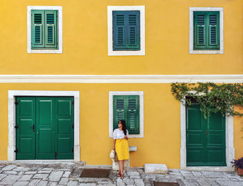 Full length of woman standing outside building