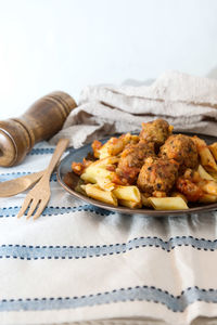 Close-up of pasta with meatballs served in plate on table