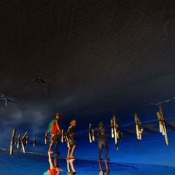 Upside down image of people reflecting on wet sand