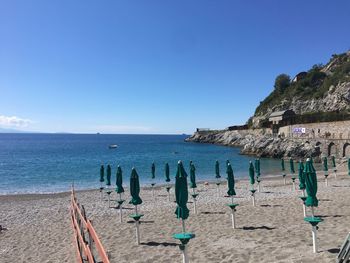 Scenic view of beach against clear blue sky