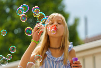 Full length of woman holding bubbles