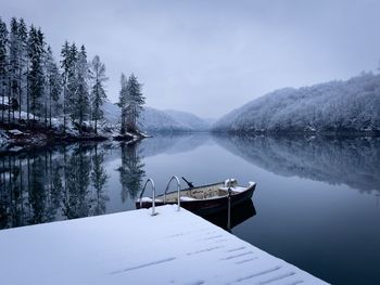 Boat on the lake in winter and trees covered in snow