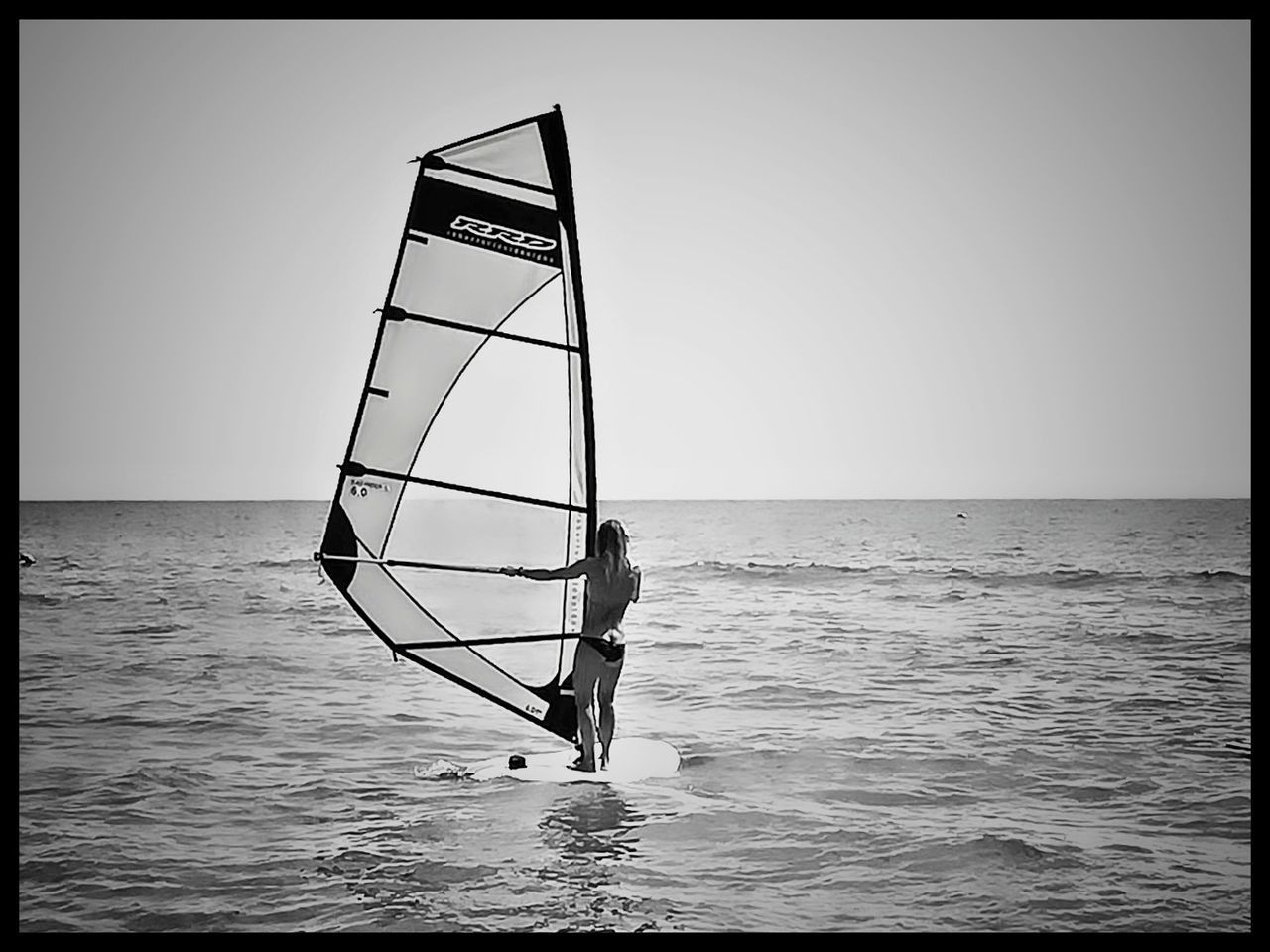 MAN STANDING ON SEA AGAINST CLEAR SKY