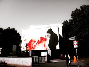 People working on street in city against clear sky