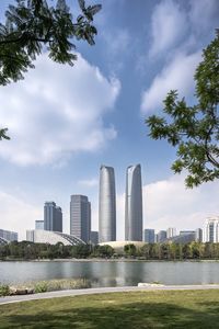 Sea by modern buildings against sky in city