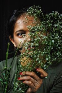 Close-up portrait of woman holding flowers