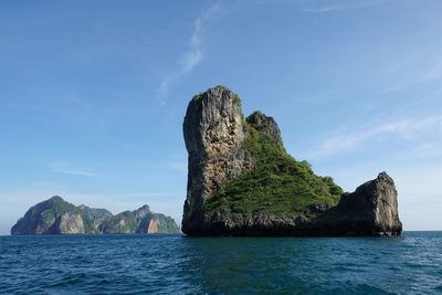 Rock formation by sea against sky