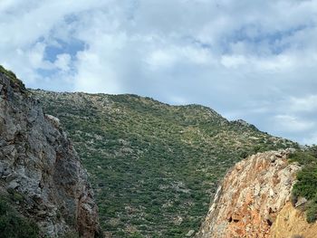 Low angle view of rocky mountain against sky