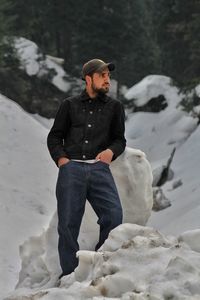 Young man standing on snow covered land